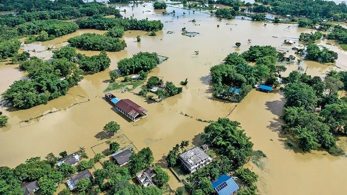 Aerial view of an Assam village with homes and farmland submerged in floodwater